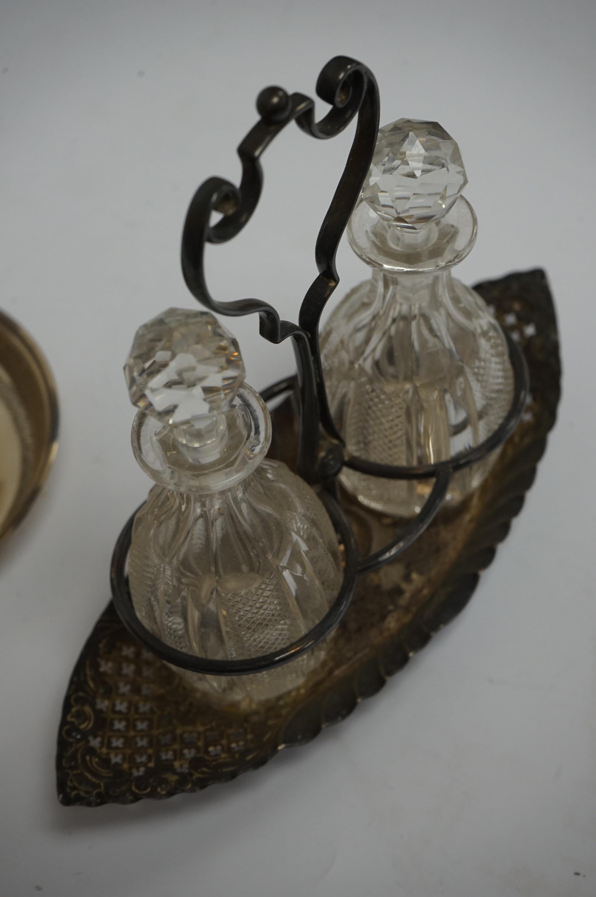 An Edwardian silver communion jug, by James Deakin & Sons, London, 1908, 15.2cm, together with a late Victorian repousse silver cruet stand with two glass bottles and stoppers, James Dixon & Sons, Sheffield, 1897 and a c